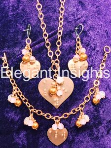 Photo of a heart pendant, bracelet, and earrings in copper with rose quartz and copper beads. 